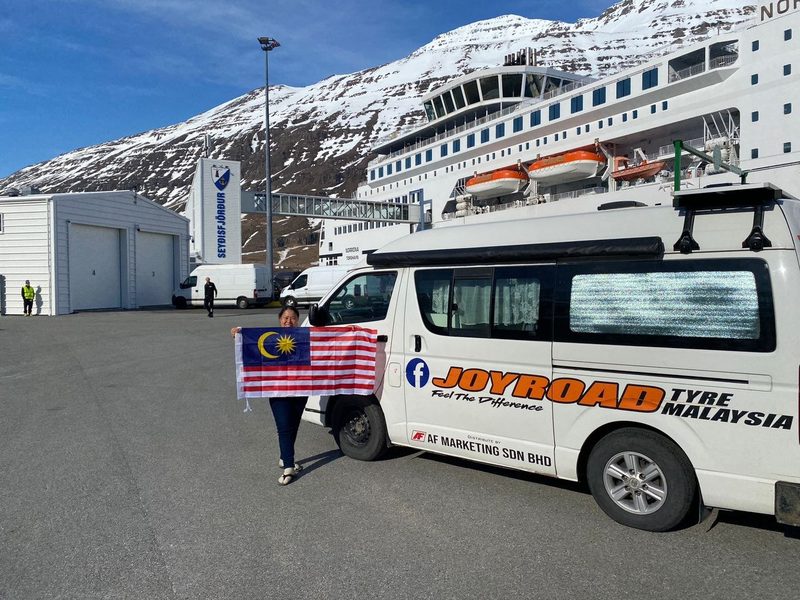 Tuzi holding the Malaysian flag beside Toyotaki and Norröna in Iceland